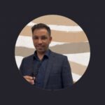 Άνδρας σε επαγγελματικό περιβάλλον, με φόντο μοντέρνο τοίχο.
